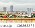 Modern apartment buildings rising above traditional houses along Tonle Sap riverbank in Phnom Penh, Cambodia 136868275