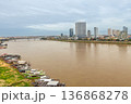 River cruise boats moored along Tonle Sap River with modern skyline in background, Phnom Penh, Cambodia 136868278