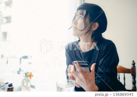 カフェでスマートフォンを見る30代日本人女性 136869345