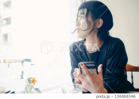カフェでスマートフォンを見る30代日本人女性 136869346