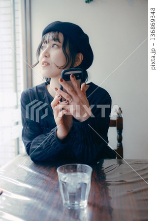 カフェでスマートフォンを見る30代日本人女性 136869348