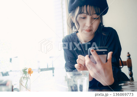 カフェでスマートフォンを操作する30代日本人女性 136869773