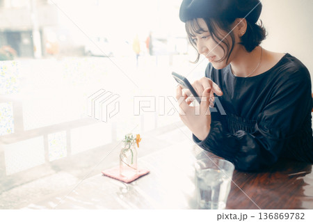 カフェでスマートフォンを操作する30代日本人女性 136869782