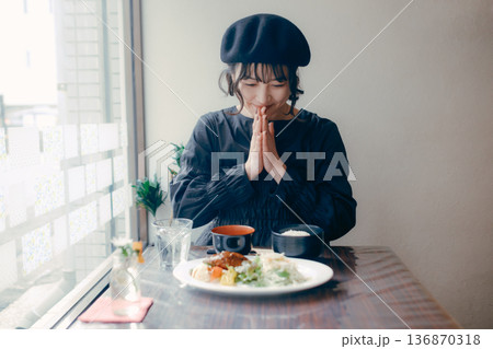ハンバーグ定食を前にいただきますをする30代日本人女性 136870318