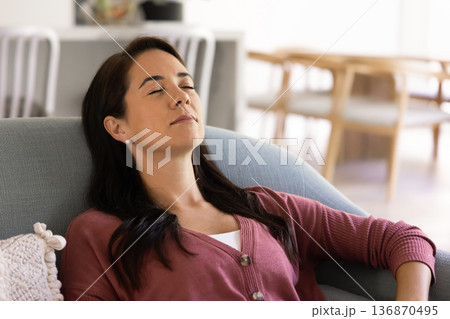 Peaceful woman resting with eyes closed on couch Peaceful woman resting with eyes closed on couch 136870495