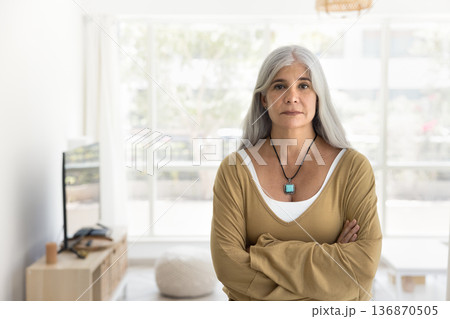 Middle-aged woman standing confidently in modern, well-lit room Middle-aged woman standing confidently in modern, well-lit room 136870505