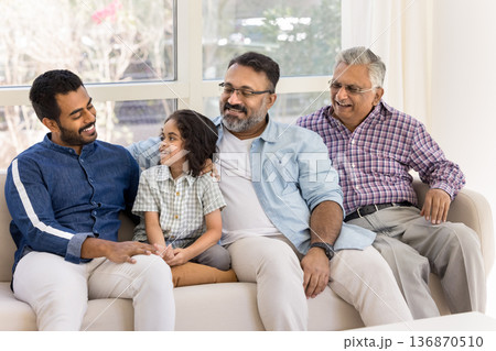 Multi generational Indian family talking seated on sofa Multi generational Indian family talking seated on sofa 136870510