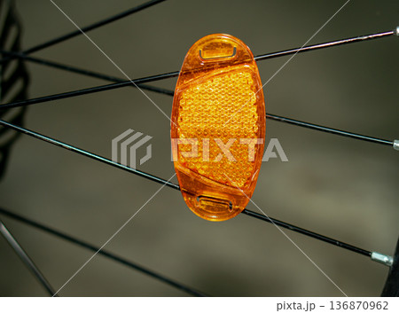 a reflector attached to a bicycle wheel. a reflector attached to a bicycle wheel. 136870962