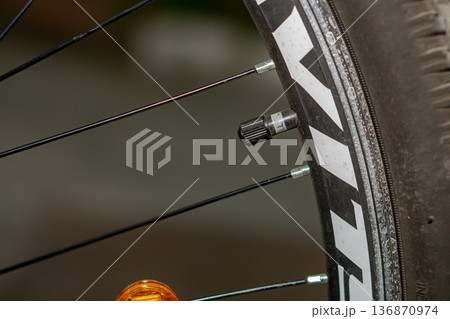 A valve with a cap on a bicycle wheel 136870974