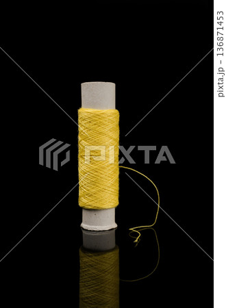 A skein of thread, a spool of thread for sewing, on a black background isolated with reflection A skein of thread, a spool of thread for sewing, on a black background isolated with reflection 136871453