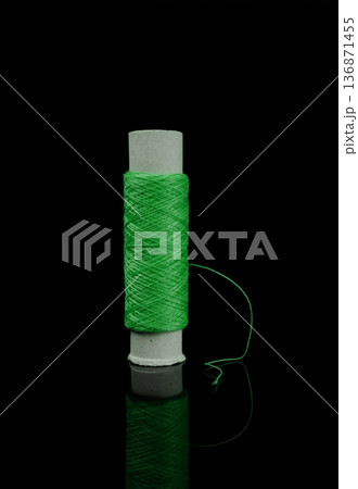 A skein of thread, a spool of thread for sewing, on a black background isolated with reflection A skein of thread, a spool of thread for sewing, on a black background isolated with reflection 136871455