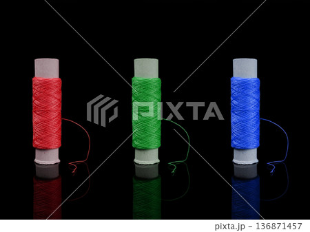 A skein of thread, a spool of thread for sewing, on a black background isolated with reflection 136871457