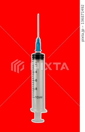 Medical syringe with a needle, ten milliliters, on a red background 136871492