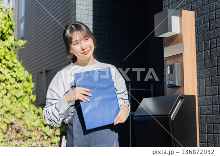 回覧板を運ぶ女性 回覧板を運ぶ女性 136872032