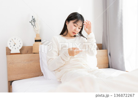 体温計で熱を測る女性 体温計で熱を測る女性 136872267