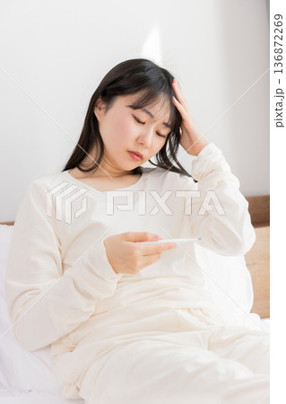 体温計で熱を測る女性 体温計で熱を測る女性 136872269