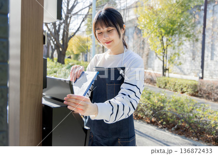回覧板を運ぶ女性 回覧板を運ぶ女性 136872433