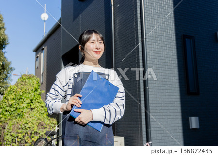 回覧板を運ぶ女性 回覧板を運ぶ女性 136872435