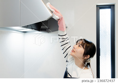 キッチンの換気扇を掃除する女性 キッチンの換気扇を掃除する女性 136872437