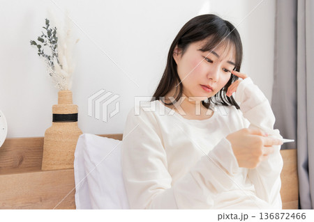 体温計で熱を測る女性 体温計で熱を測る女性 136872466