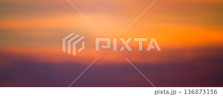 不思議な雲とオレンジ色に染まったグラデーションのある空 136873156