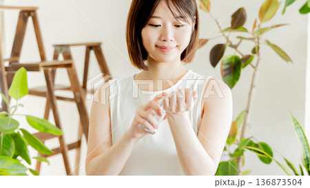 手首に香水を吹きかけるワンピースの女性 136873504