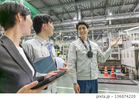 工場を視察する女性ビジネスパーソンと男性作業員 工場を視察する女性ビジネスパーソンと男性作業員 136874220