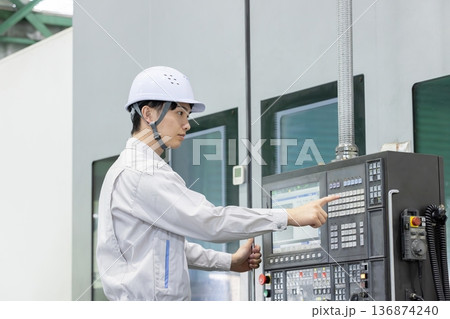 工場の操作盤の前で働く男性作業員 工場の操作盤の前で働く男性作業員 136874240