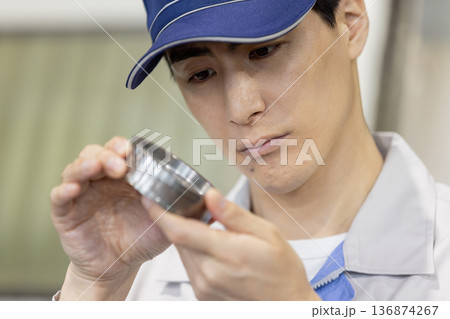 工場で旋盤加工品・フライス加工品を確認する男性作業員 工場で旋盤加工品・フライス加工品を確認する男性作業員 136874267