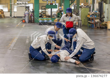 工場で倒れた作業員をAEDで救護するグループ 136874277