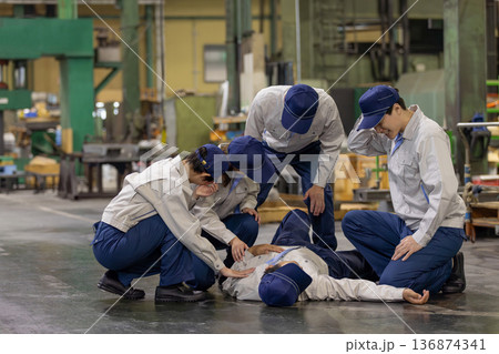 工場で倒れた作業員を救護するグループ 136874341
