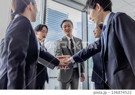 円陣で手を重ねるビジネスグループ 136874522