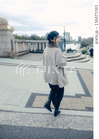 冬の都会を歩く笑顔の30代日本人女性 冬の都会を歩く笑顔の30代日本人女性 136875381