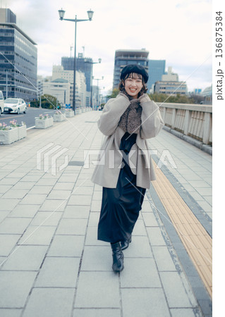 冬の都会を歩く笑顔の30代日本人女性 冬の都会を歩く笑顔の30代日本人女性 136875384