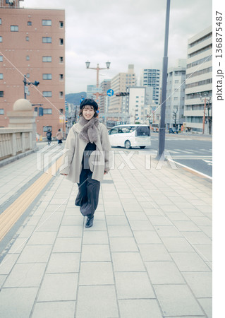冬の都会を歩く笑顔の30代日本人女性 136875487