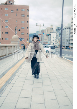 冬の都会を歩く笑顔の30代日本人女性 136875489