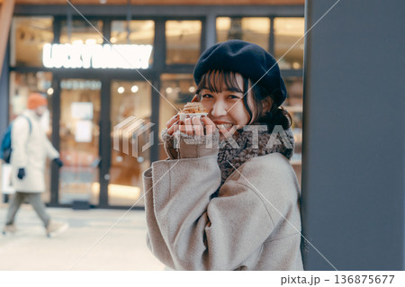 冬の街でスイーツを楽しむ30代日本人女性 136875677