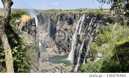 ザンビアの乾季のビクトリアフォール渓谷 晴天の昼に崖の間を流れる滝の風景 観光旅行向け背景素材 136876468