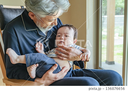 赤ちゃんを抱っこするシニア男性 136876656