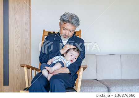 赤ちゃんを抱っこするシニア男性 赤ちゃんを抱っこするシニア男性 136876660