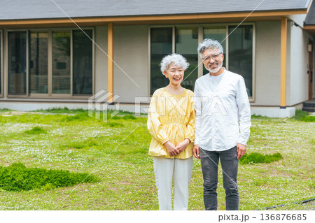 笑顔で住宅の前に立つシニアカップル 笑顔で住宅の前に立つシニアカップル 136876685