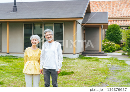 笑顔で住宅の前に立つシニアカップル 笑顔で住宅の前に立つシニアカップル 136876687