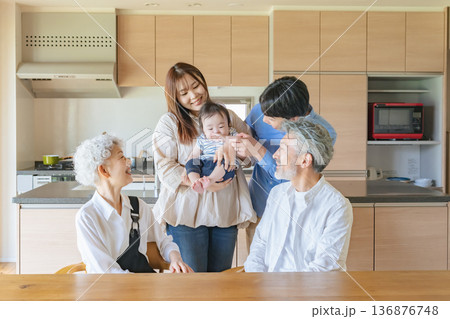 笑顔で赤ちゃんを囲む三世代家族 136876748