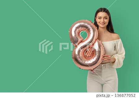 Woman holds big balloon number 8 for Women's Day 136877052