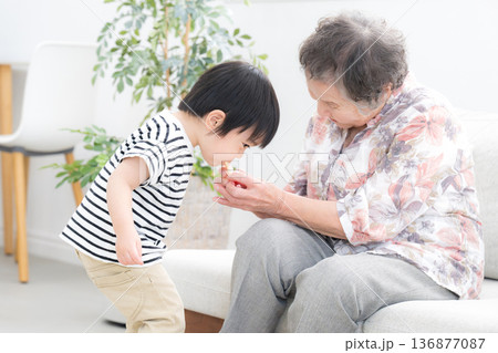 祖母と孫が触れ合う時間 孫にこっそりお菓子をあげちゃうおばあちゃん　 136877087