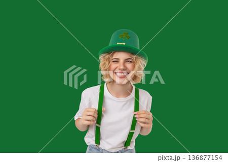 Woman wears a green hat and holds suspenders with joy Woman wears a green hat and holds suspenders with joy 136877154