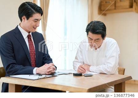 書類の書き方をサポートする士業の男性 書類の書き方をサポートする士業の男性 136877346