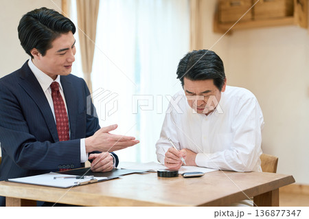 書類の書き方をサポートする士業の男性 136877347