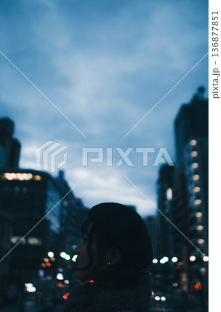 夜の都会で佇む女性のシルエット 136877851