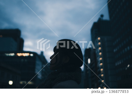 夜の都会で佇む女性のシルエット 136877853